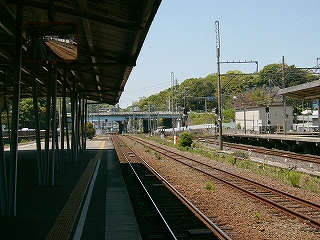 遠くは緑が多い。少し向こうで、水色の橋げたを持つ道路がオーバークロスしている。