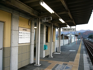 上屋の下から見た駅舎前の雰囲気。新しい駅舎の壁は薄い黄色とくすんだ濃い色で配色され、ホームには黄色の点字ブロックがしっかり設置されている。