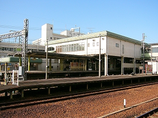 手前に簡易なつくりの3番線ホーム、その奥に近鉄のホーム。近鉄のホームを跨ぐように橋上駅がある。