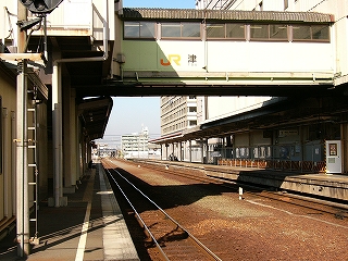 右手に線路内と駅ビルのある片面ホーム、上方に薄みどりの短い連絡通路。