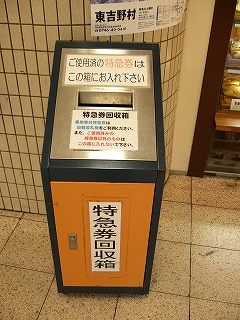 縦長のステンレスの特急券回収函。上の面は手前に向かって斜めになっていて、きっぷを入れるための口があけられてある。