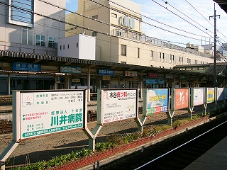 広告の並びを左斜めに見て。この向こうにJRの3・4番線島式ホームが並行して見えている。