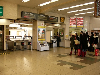 太い柱を挟んで2レーンずつの自動改札。頭上にはLED式列車案内が横に3つ並べられて設置されてある。