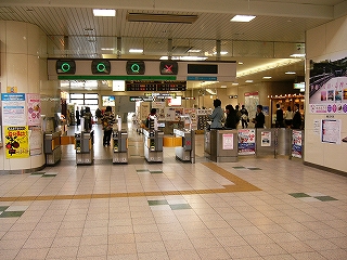 4レーンの自動改札と、1レーンの有人改札。上方にバツとマルが表示され、出口と入口を示している。