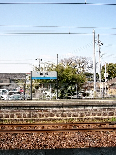 焦げ茶の石積みのホームと駅名標。