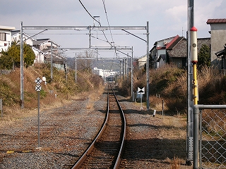 2線分の門型架線柱の中を悠々と1線が延びる。