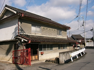 二階建てのモルタル作りの古い民家。