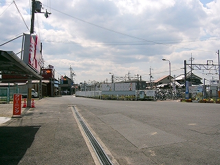 輪郭のゆがんだ道。3階建ての建物、民家がぱらぱらとある。