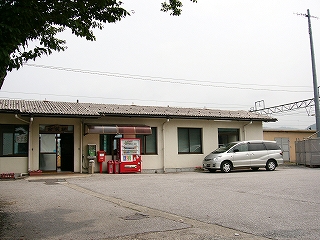 クリーム色の壁の平屋の駅舎。屋根は波板。