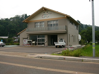 二階建ての大きな切妻の真新しい建物。壁は落ち着く泥色。