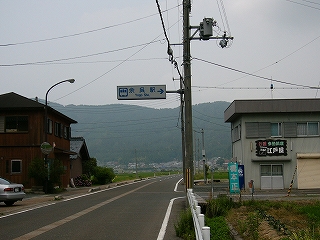 広い道路に右に折れる道。上には余呉駅の案内看板。